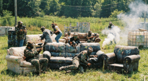 Paintball players shooting at each other and couches